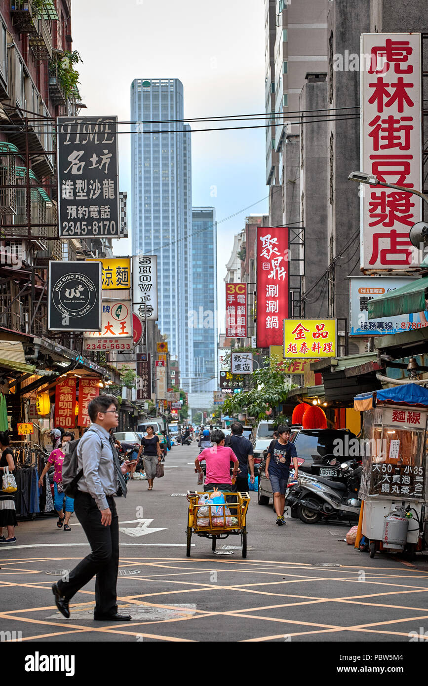 Asiatische Markt mit Werbung Schilder und Wolkenkratzer Silhouette im Hintergrund Stockfoto