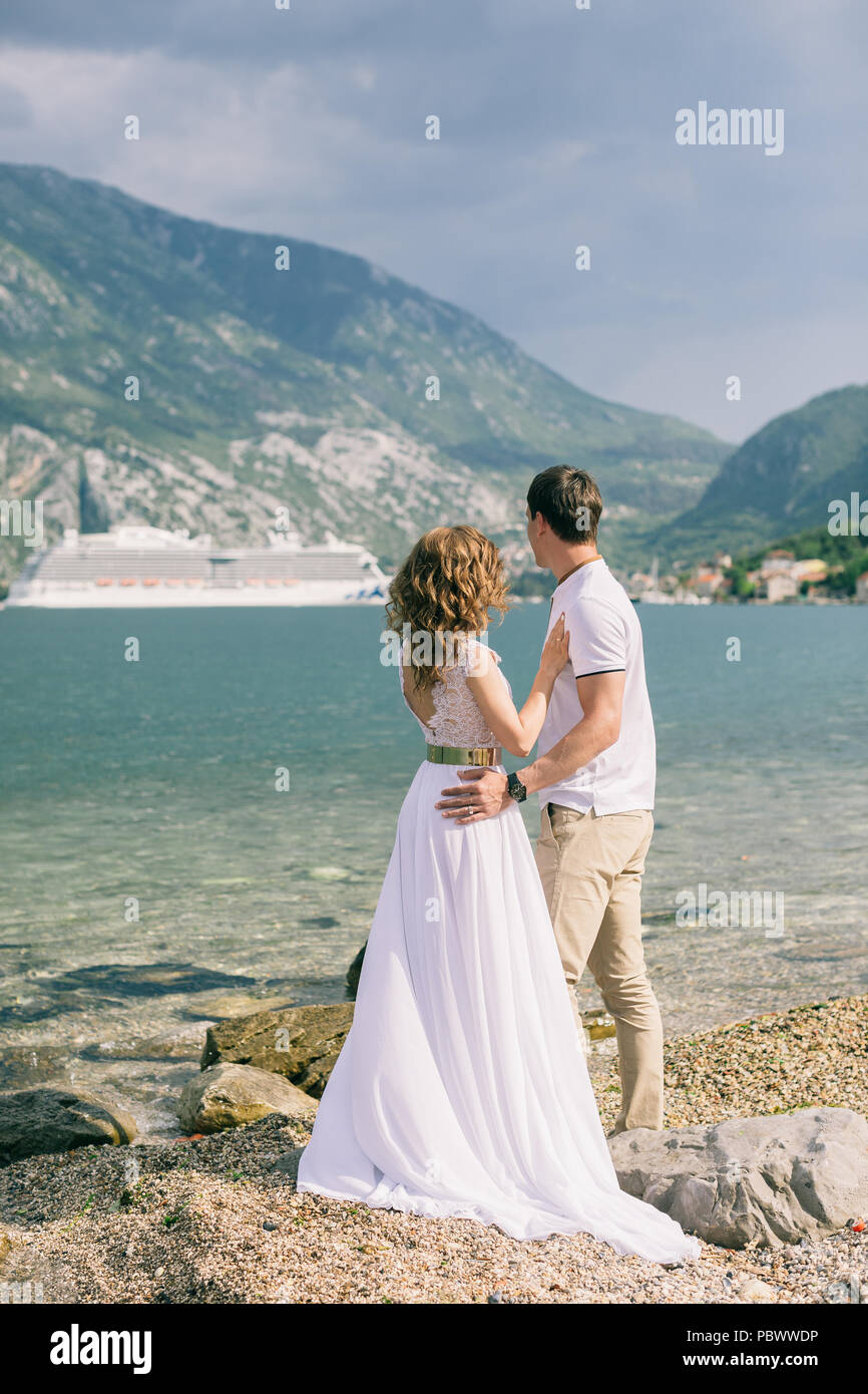 Paar reisen mit Schiff im Hintergrund. Paare auf Hochzeitsreise waitinf für Cruise Liner Stockfoto