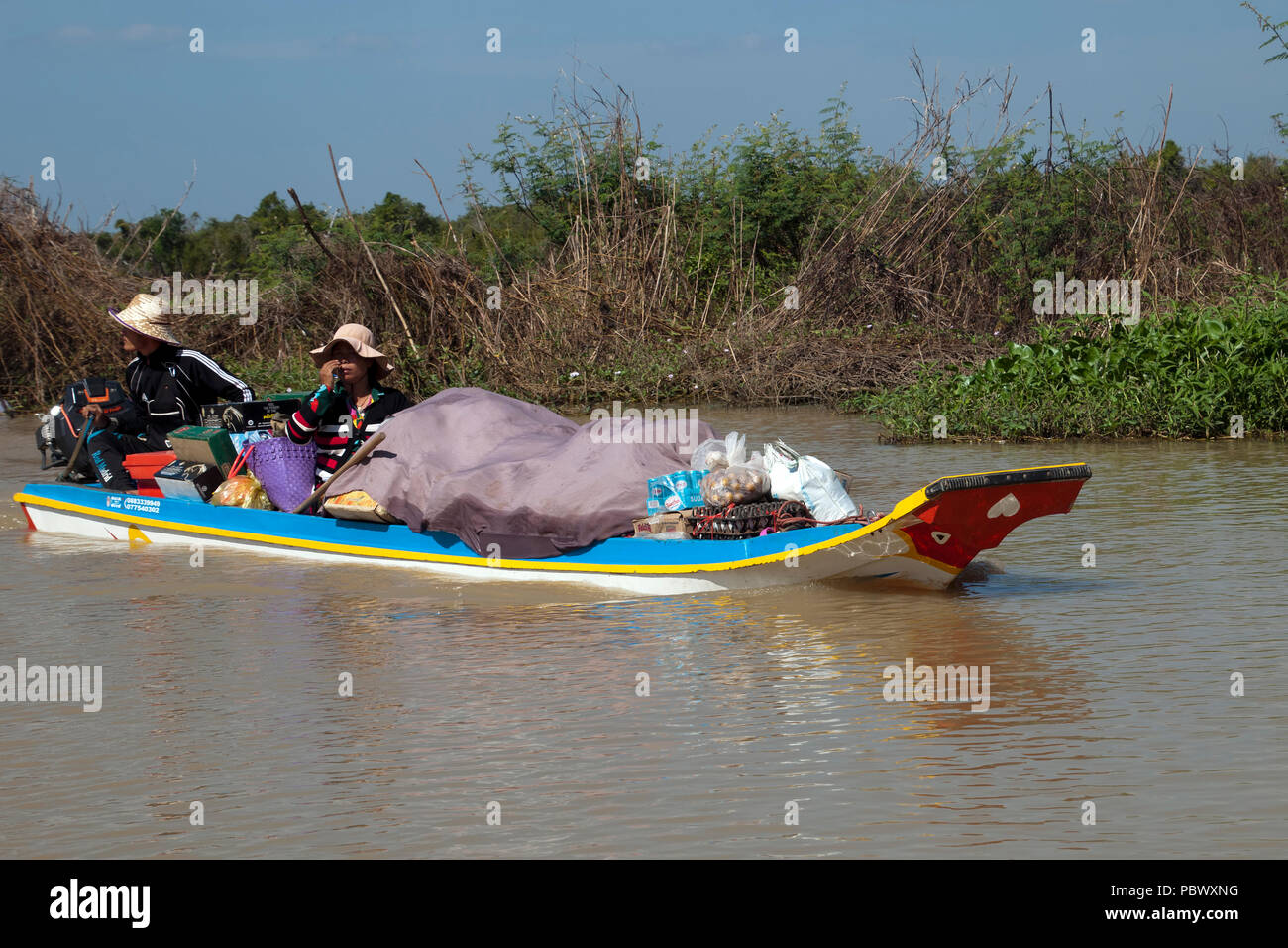 Sangker River, Provinz Battambang Kambodscha Jan 4 2018, Paar im Boot mit Lebensmitteln zurück zu Fishing Camp gestapelt Stockfoto