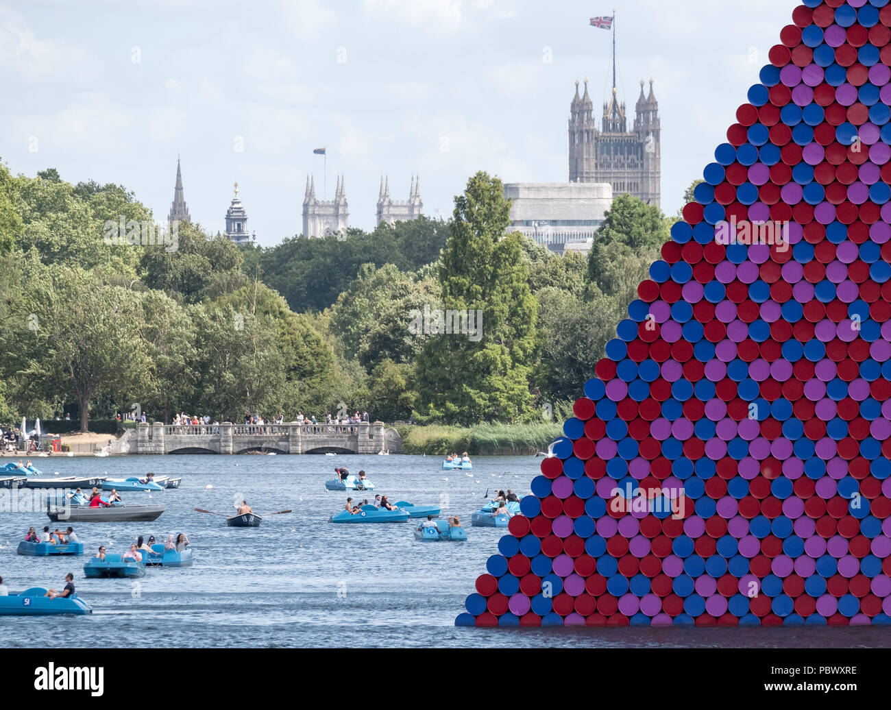 Mastaba kunst Installation von Christo und Jeanne-Claude, schwimmend auf dem Serpentine Lake im Hyde Park, mit den Häusern des Parlaments im Hintergrund. Stockfoto