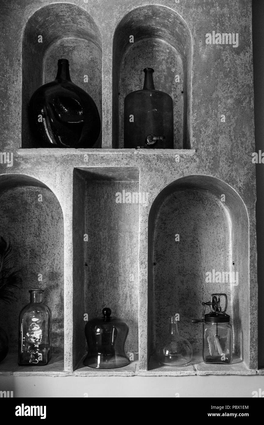 Nischen mit Glasflaschen und Küchenutensilien in dem Hotel Cal Sastre, Santa Pau, Katalonien Stockfoto