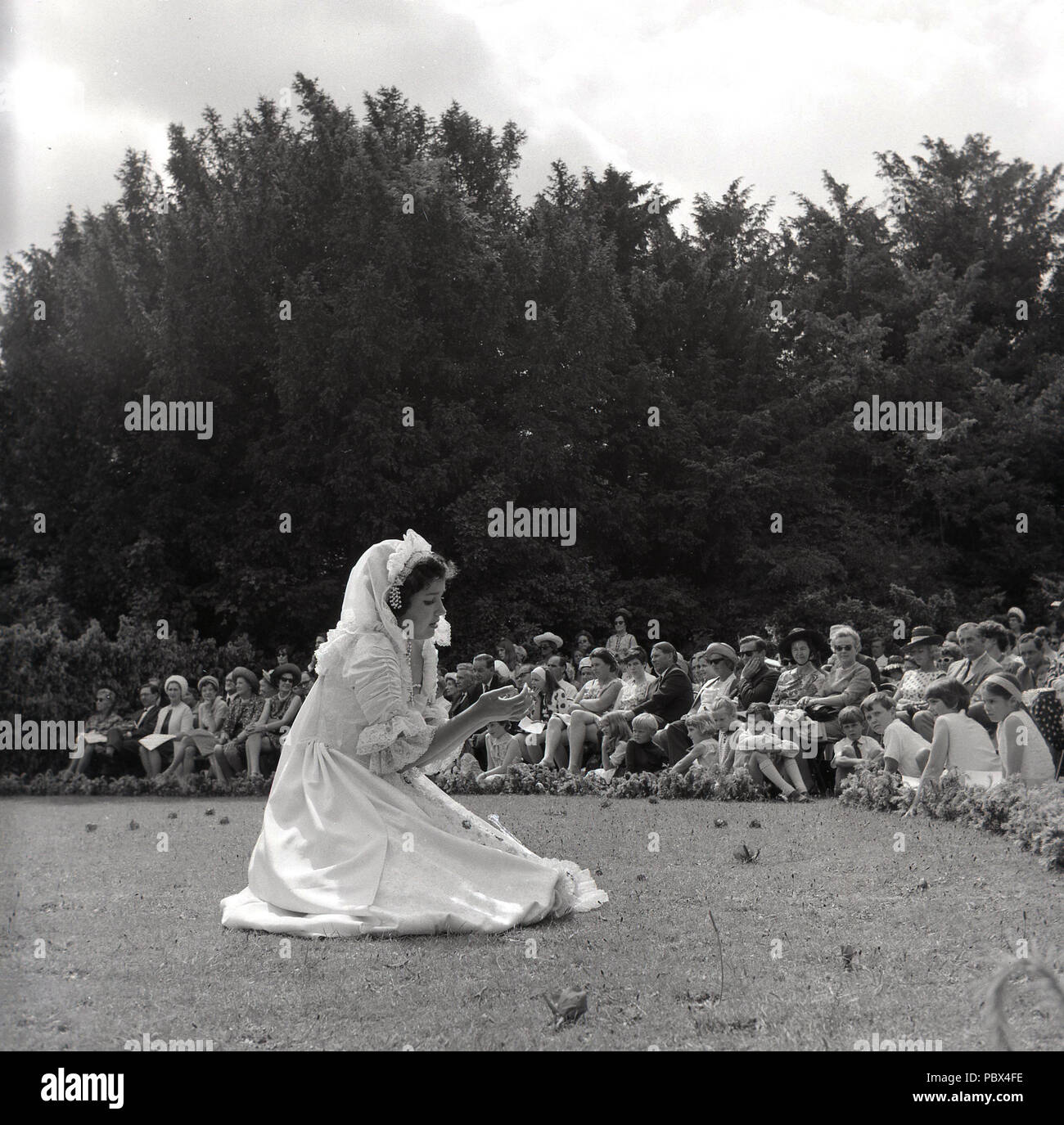 1964, Tring, Kultur, ein junges Mädchen, die in der Open-air-außen vor einem sitzenden Publikum auf dem Gelände des Tring Park Schule für darstellende Künste, ursprünglich der Arts Educational School. Stockfoto
