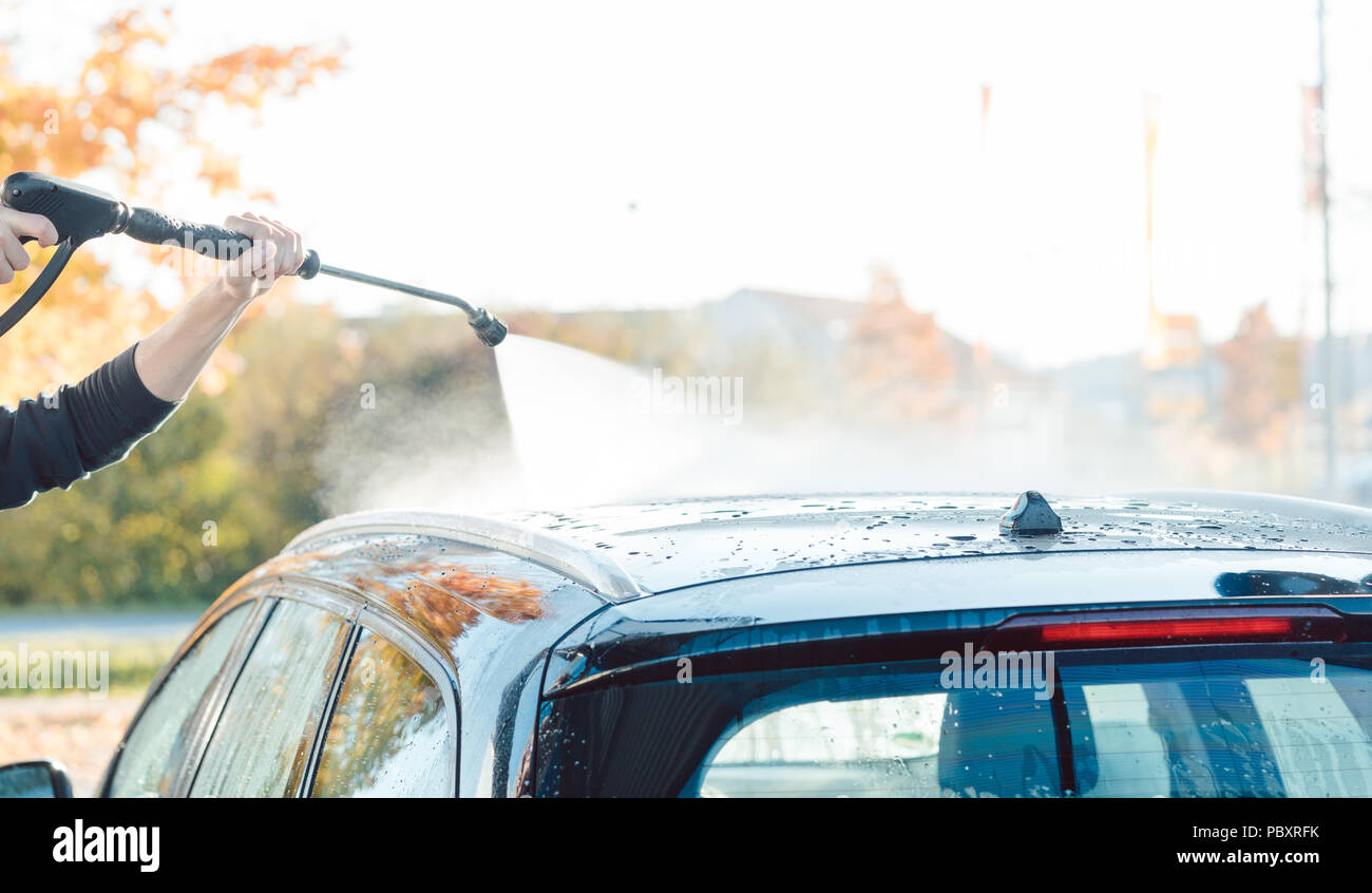 Arbeitnehmer Reinigung Auto mit hohem Druck Wasser Düse Stockfoto