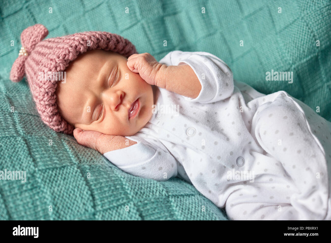 Baby Mädchen liegt auf dem Rücken auf die Ohren. Neugeborenes Baby schließt  mit den Ohren und Schlafen Stockfotografie - Alamy