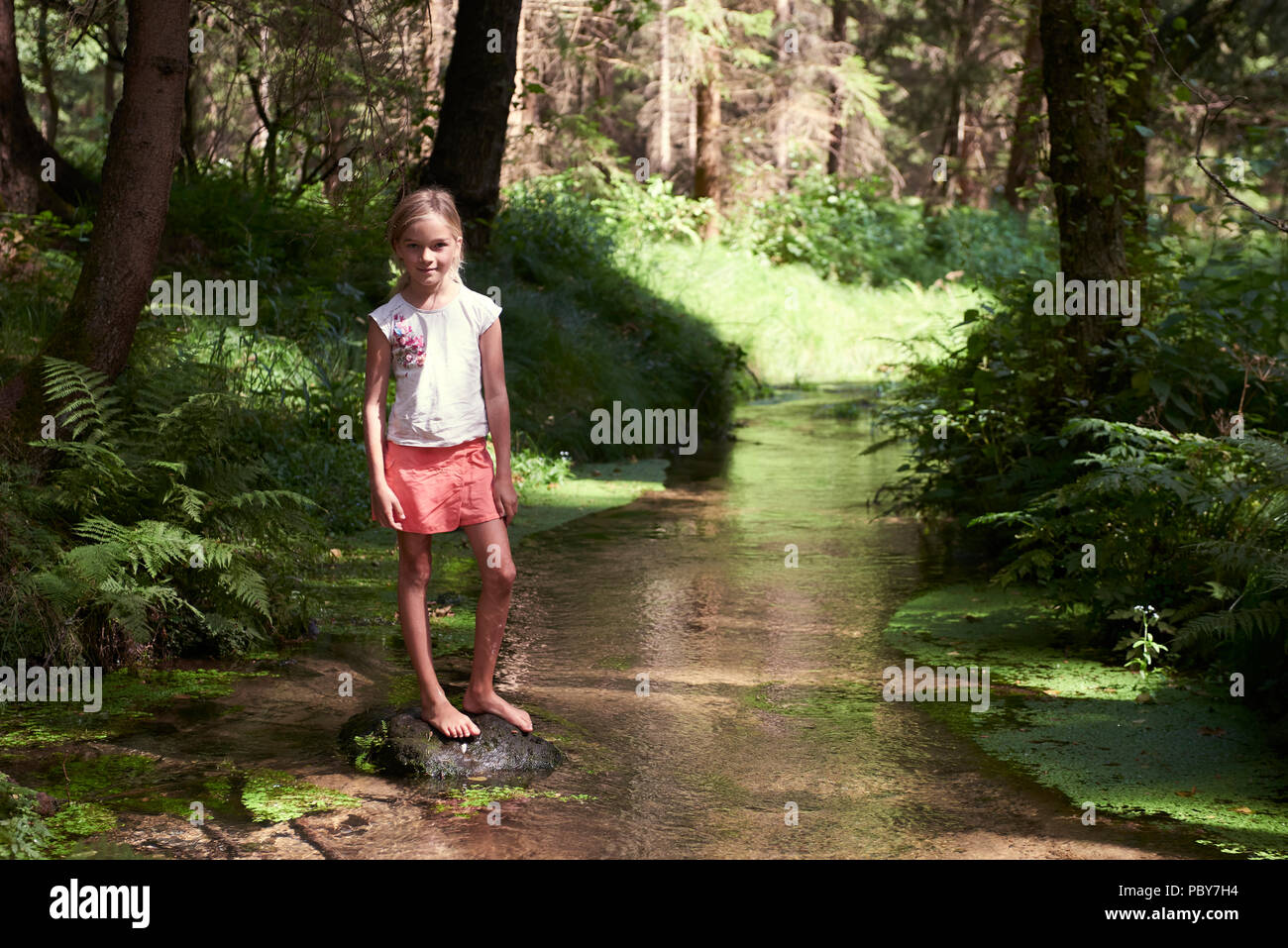 Kind niedlich blonde Mädchen spielen in den Creek. Gril Wanderungen in Wald und Natur zu erkunden. Sommer Kinder Spaß. Kinder Aktivitäten im Sommer Stockfoto