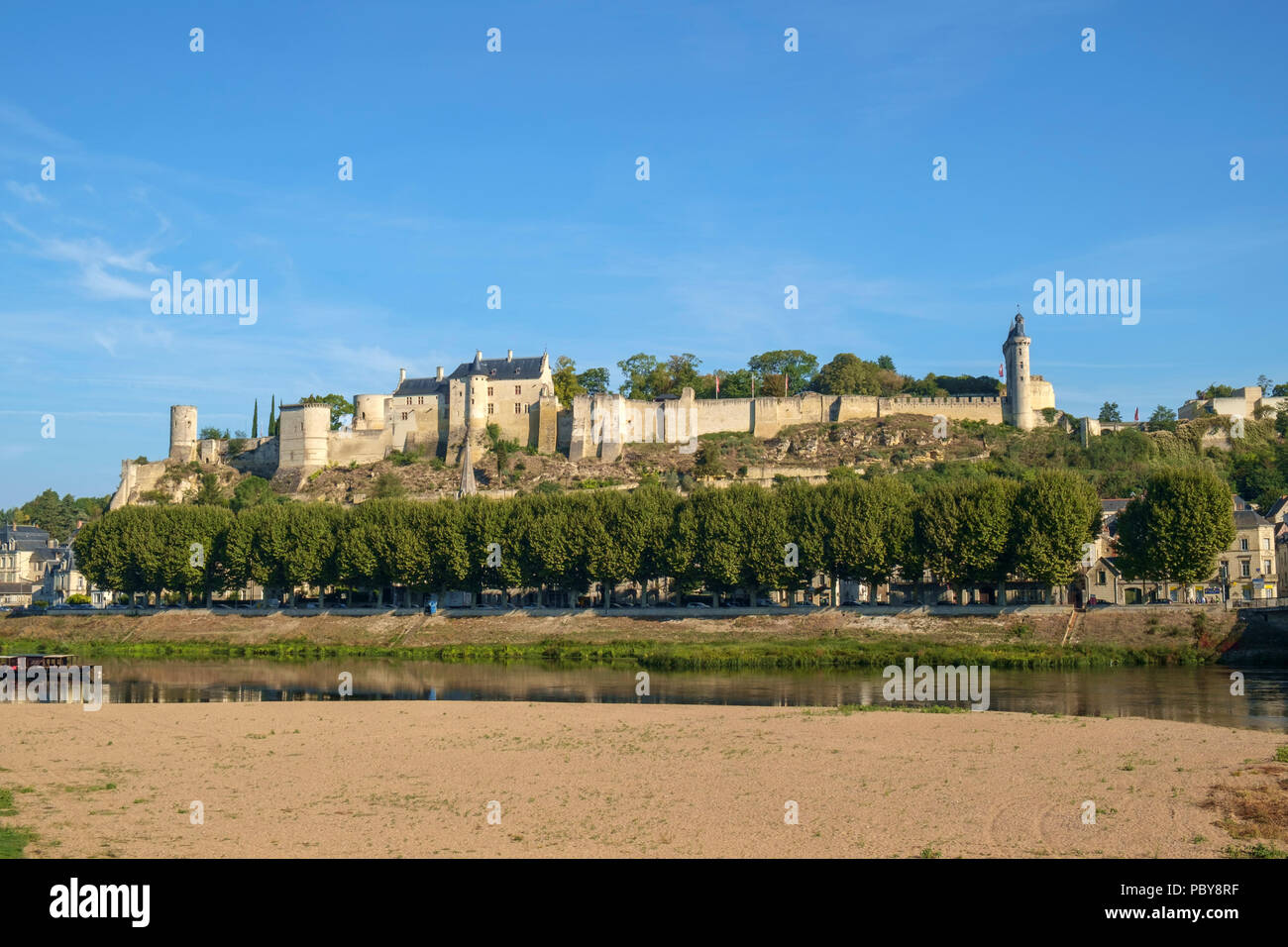 Chinon Schloss befindet sich auf dem Hügel im frühen Herbst morgen Sonnenschein hoch über dem Fluss Vienne, Indre-et-Loire, Frankreich. Der Fluss hat viel weniger Wasser am Ende des Sommers. Stockfoto