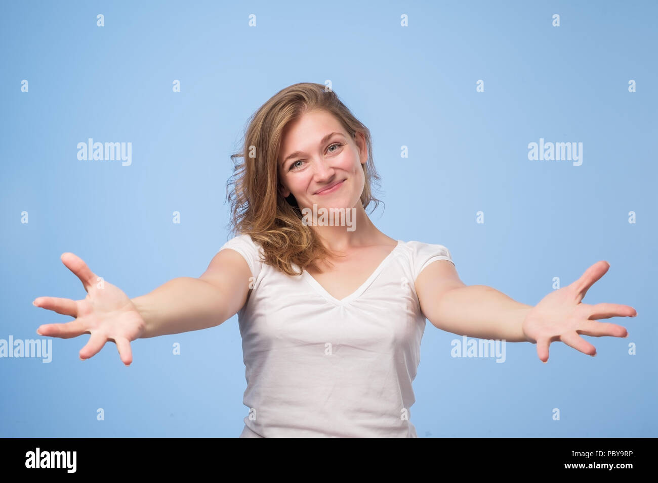 Europäische Frau auferweckt Palmen arme Hände an Sie, über blauen Hintergrund isoliert. Stockfoto