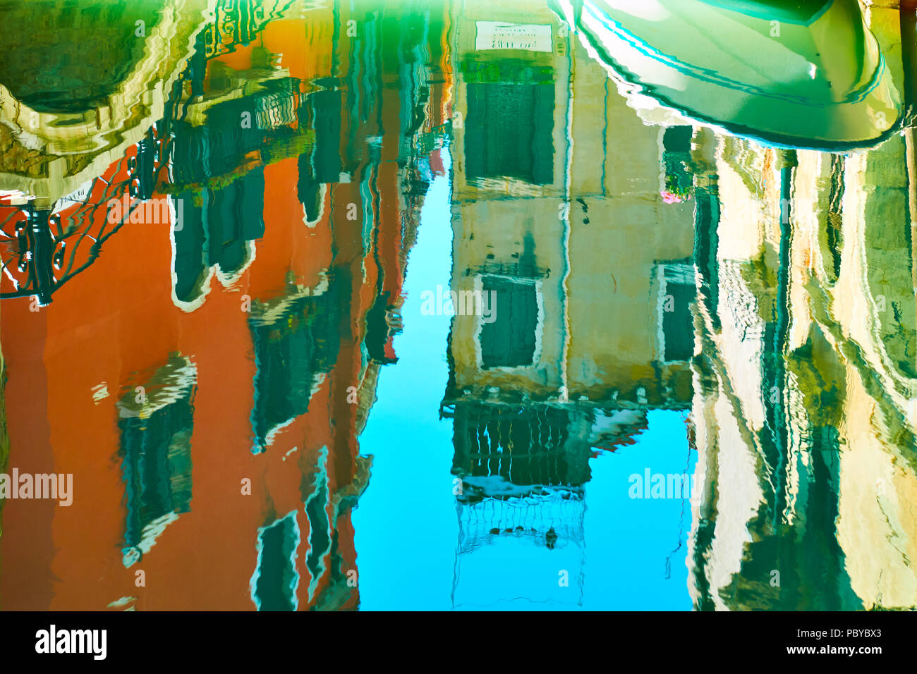 Venezianischer Spiegel - Gebäude, kleine Brücke, Boot und blauer Himmel im Wasser Oberfläche des Kanals widerspiegeln. Venedig im Wasser Reflexionen Stockfoto