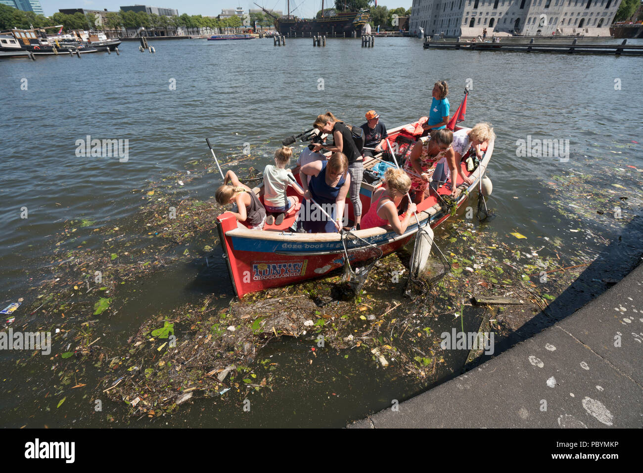 Die Stiftung Kunststoff Wal ist Mmking den Amsterdamer Grachten frei von Kunststoff. Die Boote von Kunststoffabfällen aus den Grachten von Amsterdam. Stockfoto