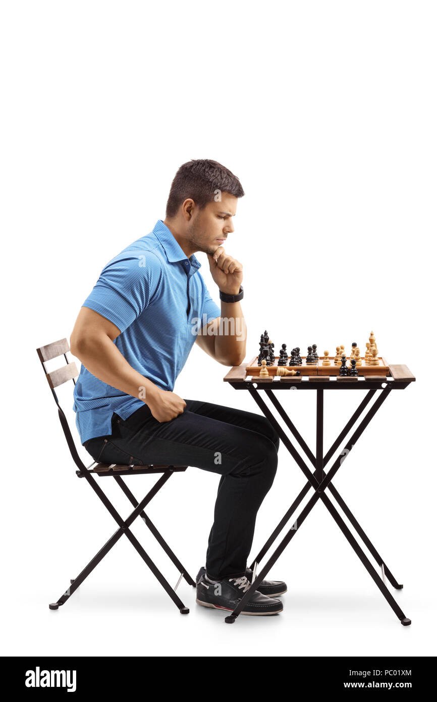 Nachdenklicher junger Mann an einem Tisch in ein Schachbrett, auf weißem Hintergrund suchen sitzt Stockfoto