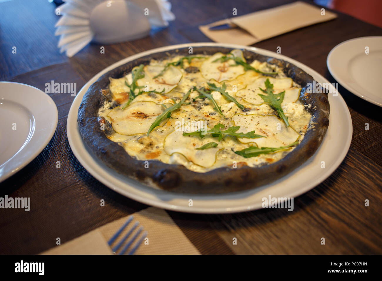 Schwarzer Käse Pizza serviert am Tisch im Restaurant Stockfoto