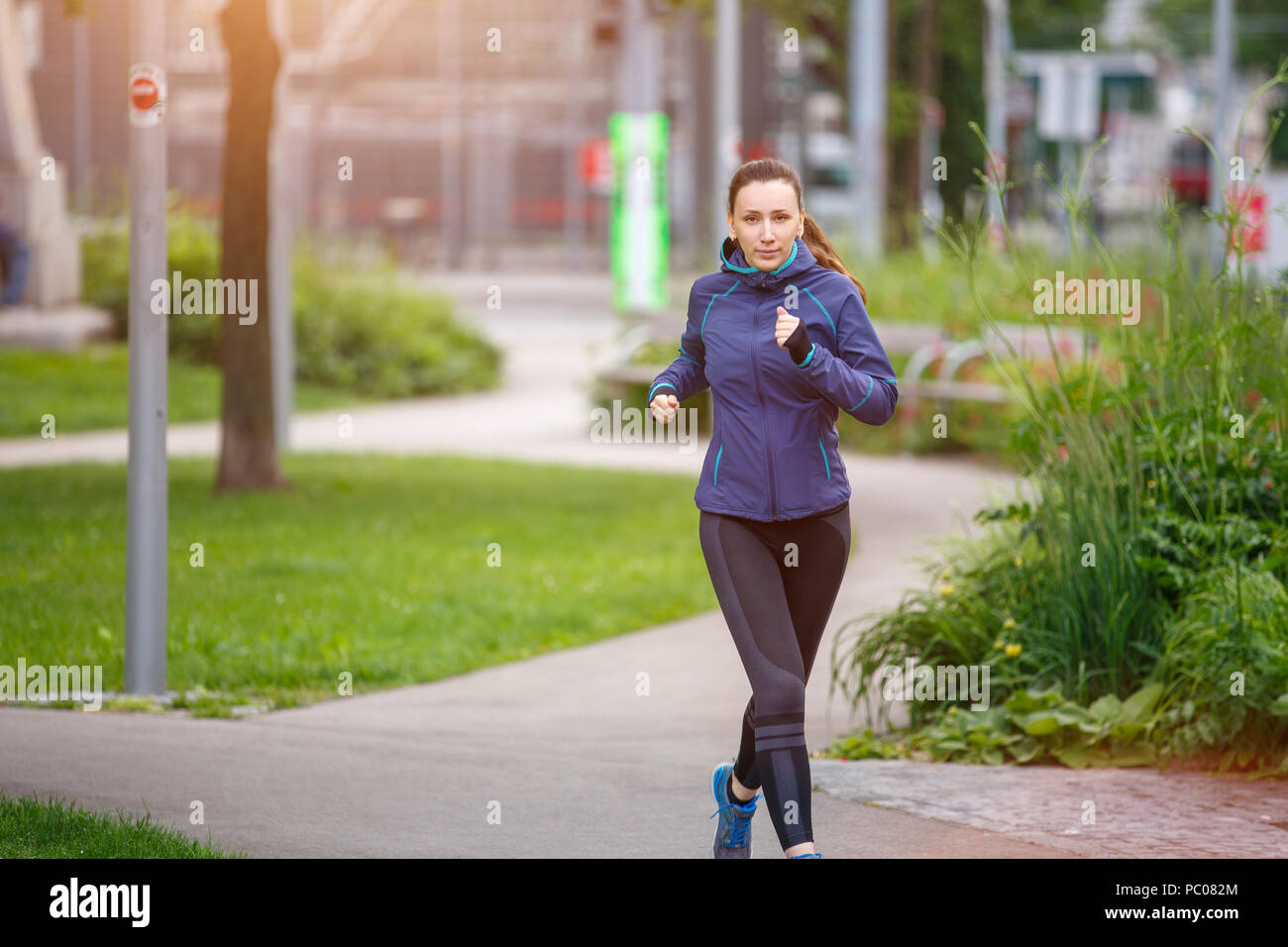 Junge Frau am Morgen im City Park läuft Stockfoto