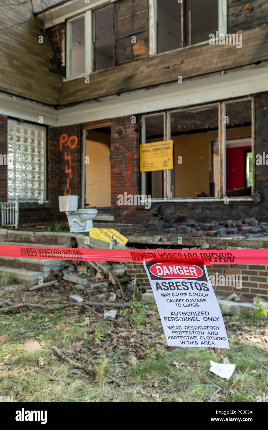 Detroit, Michigan - eine Warnung über Asbest hängt außerhalb eines verlassenen Hauses für den Abriss vorbereitet. Die Unterkunft wird für eine verwendet werden. Stockfoto