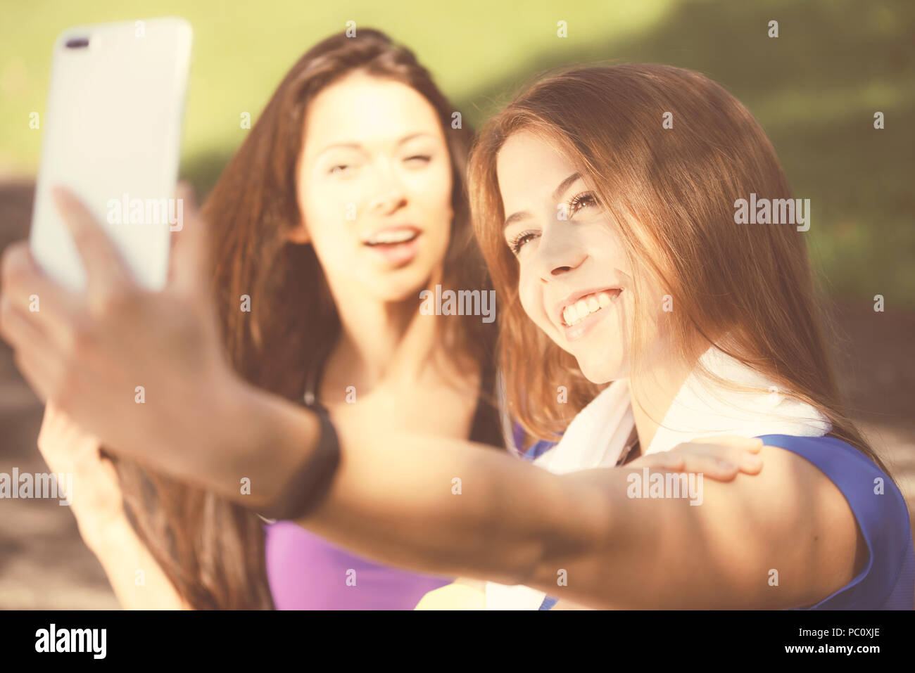 Millennials lifestyle Konzept - zwei Sport Mädchen nehmen eine selfie und Lächeln beim Training im Freien an einem sonnigen Tag (Vintage Effekt) Stockfoto