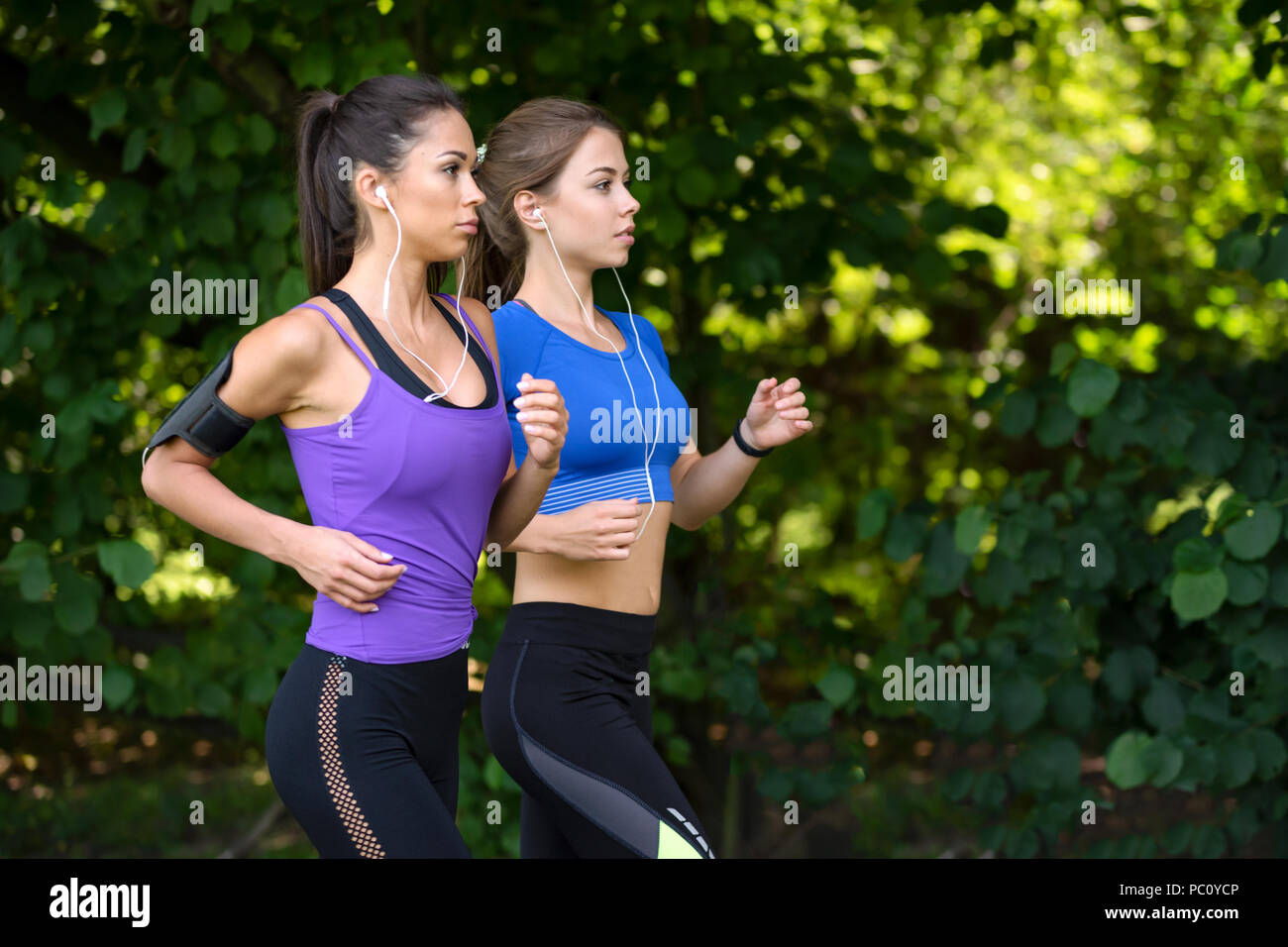 Zwei schöne und attraktive Fitness Mädchen sind Joggen im Park an einem sonnigen Morgen Stockfoto