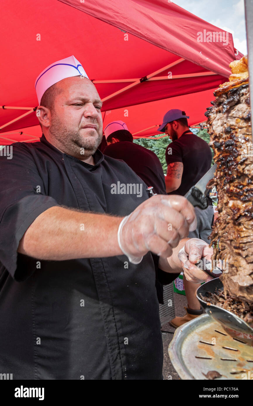 Dearborn, Michigan - ein Mann Scheiben Fleisch aus einem ROTISSERIE an einem Muslimischen politische Kundgebung. Das Fleisch ist Halal - in Übereinstimmung mit den Islamischen diätetische l vorbereitet Stockfoto