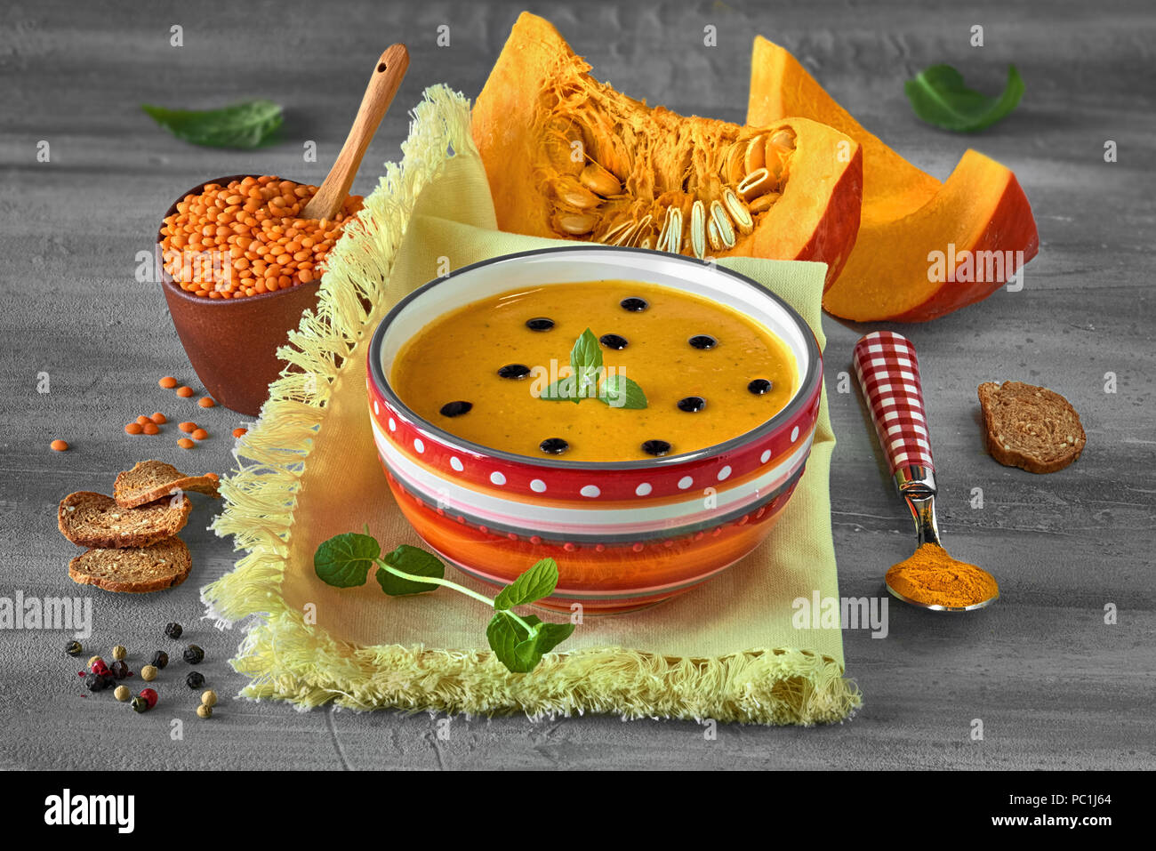 Würzige Kürbissuppe mit roten Linsen und Kurkuma serviert mit Minze und Tropfen Aceto Balsamico. Suppe Zutaten werden auf Holz- rustikalen backgrou Stockfoto