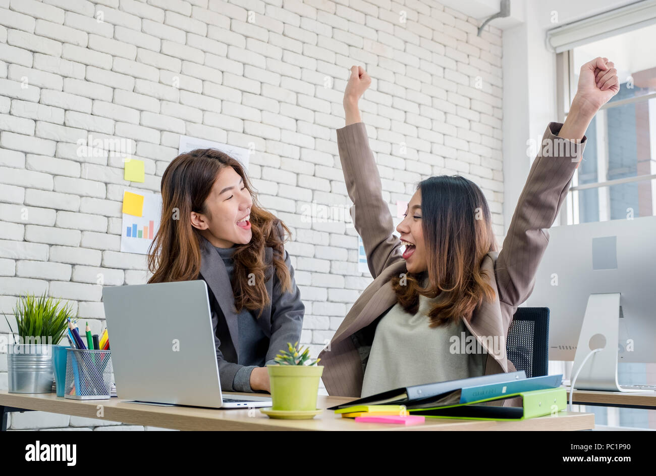 Zwei Kollegen Geschäftsfrau Arme für gute Nachrichten von Job auf Laptop über die Arbeit im Büro. Digital Business Lifestyle Konzept Stockfoto