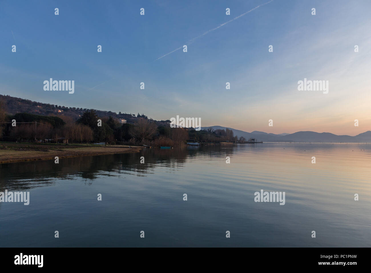 Ein Shooting für einen Sonnenuntergang über einem See, mit schönen, warmen Farben und viele diagonalen Linien durch Wolken und Wasser Wellen erstellt Stockfoto
