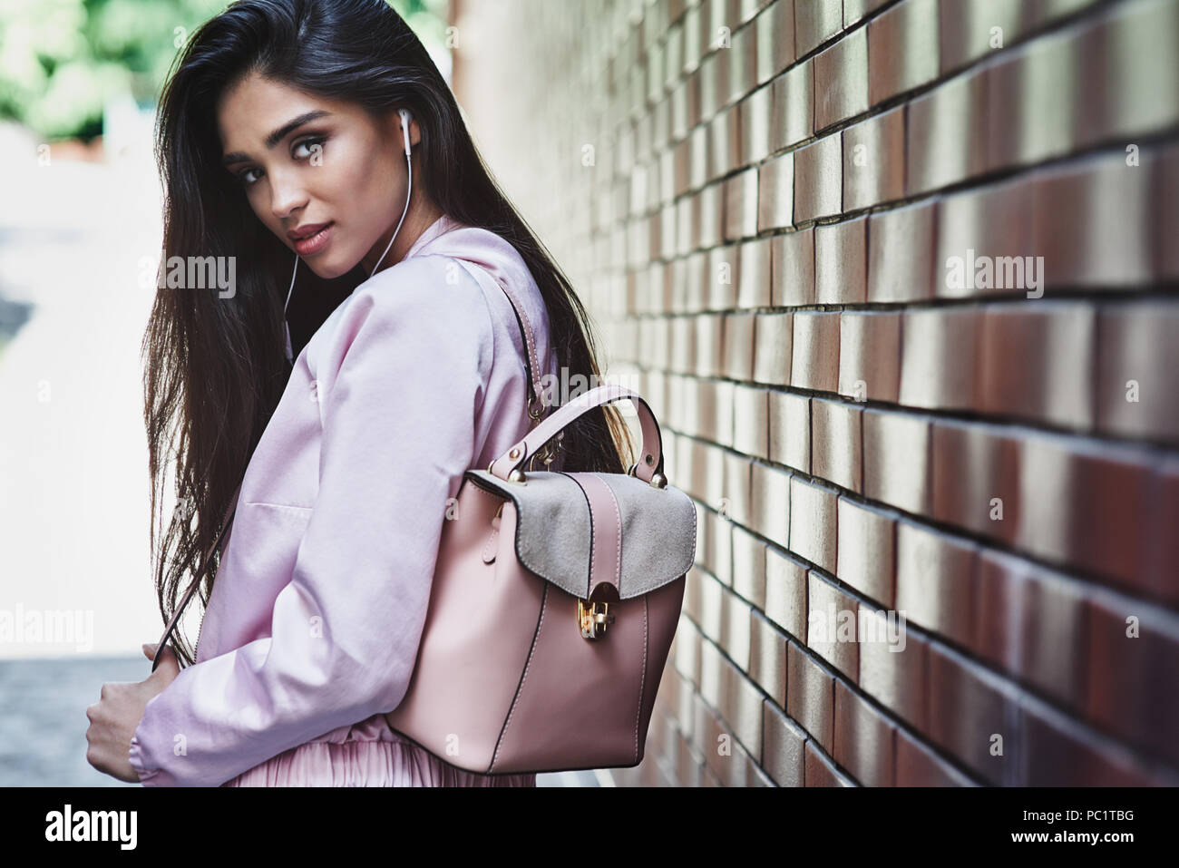 Junge Frau in rosa Jacke tragen Rucksack wandern in der Nähe von Wall l Stockfoto