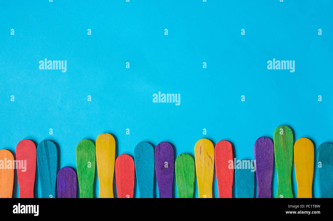 Buntes Holz eis Stick auf blauem Hintergrund. Kopieren Sie Platz. Stockfoto
