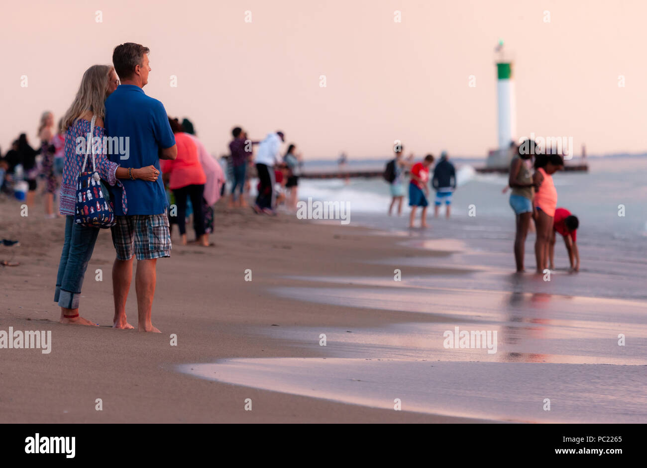 Einen atemberaubenden Sonnenuntergang beginnen unter dem horizion zu gleiten, während die Leute am Strand in Grand Bend sammeln. Stockfoto