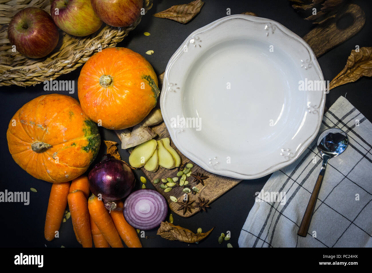 Leere Suppenschüssel und Herbst Gemüse: Kürbis, Karotten, Äpfel, Zwiebeln und Knoblauch. Herbstliche Stimmung. Stockfoto