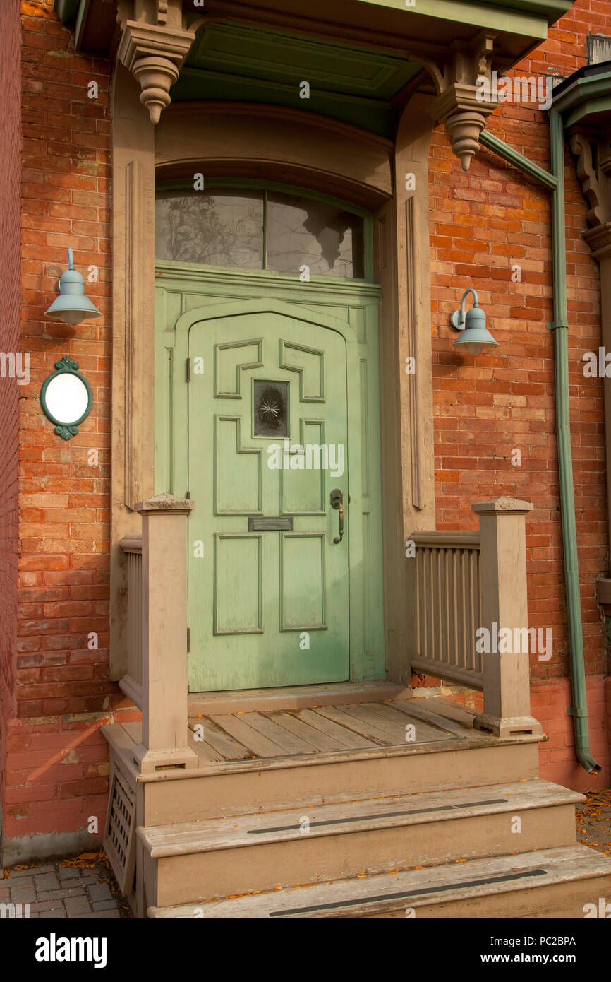 Grüne Holztür und ein Haus aus Backstein in Kanada Stockfoto