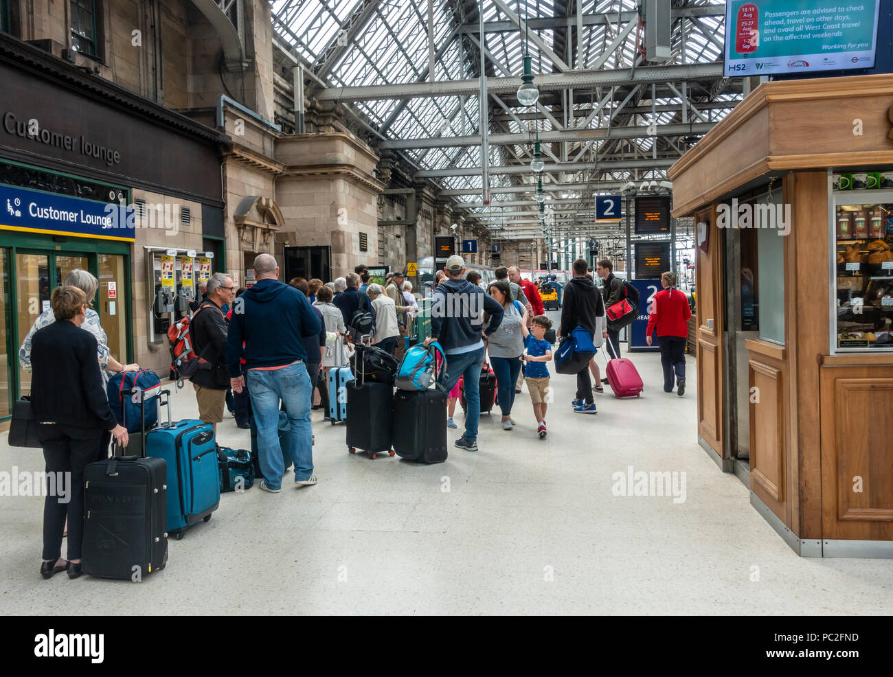 Passagiere queuing Board eine Jungfrau Zug vom Bahnsteig 1 in Glasgow Central Station zu. Zug Reisen, rollenden Gepäck, stehend, wartend in Zeile Stockfoto