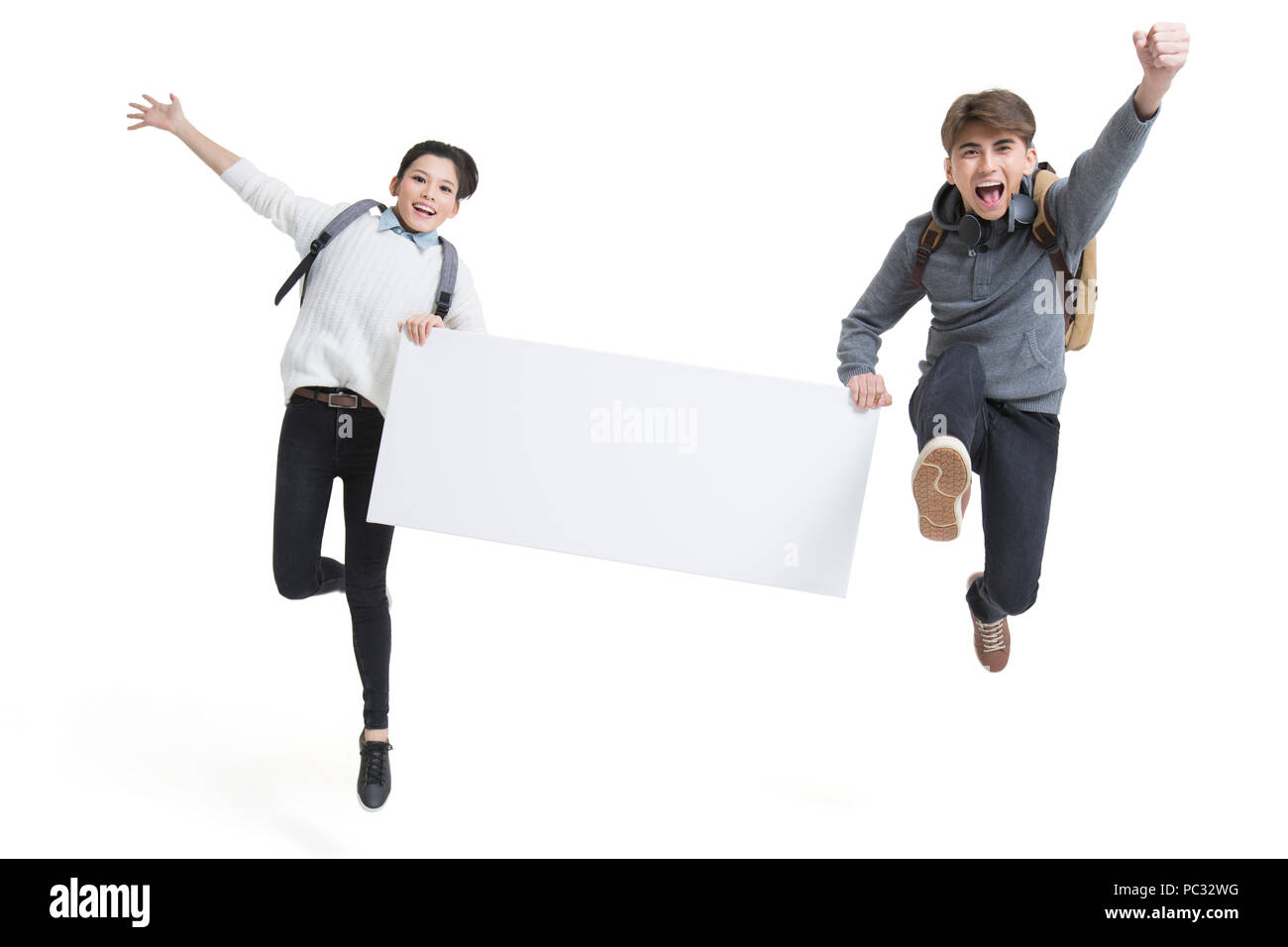 Fröhliche Studenten Holding ein Whiteboard springen Stockfoto