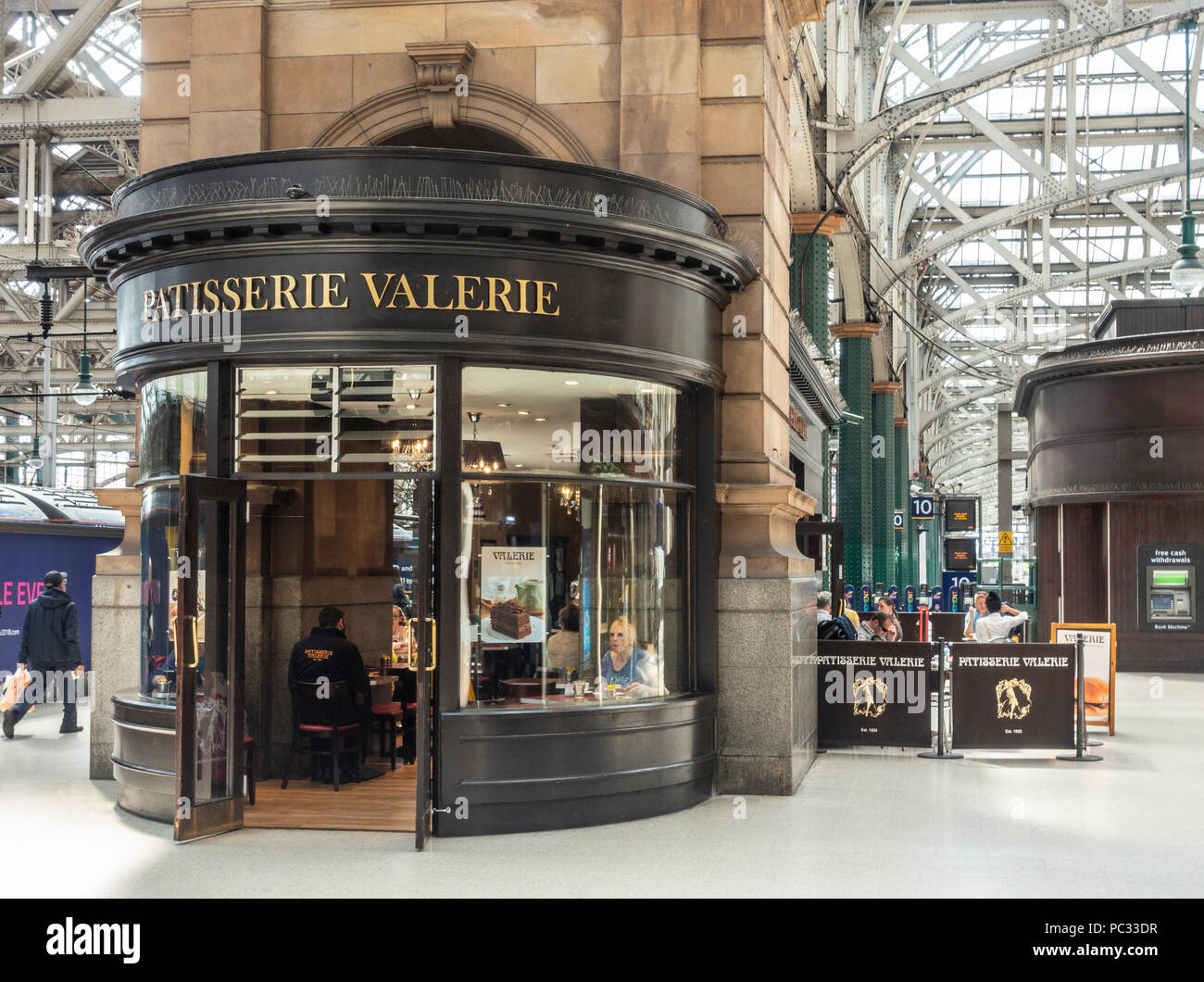 Von außen, und Kunden in der Niederlassung der Patisserie Valerie Konditorei cafe in Glasgow Central Station. Stockfoto