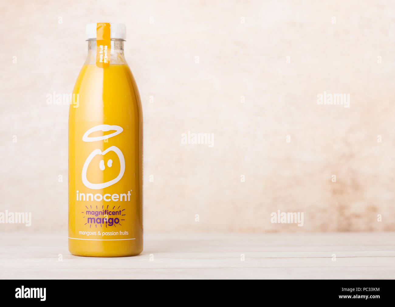 LONDON, Großbritannien - 10 August 2018: Flasche unschuldige Bio smoothie Fruchtsaft Getränk mit Mango Geschmack auf Holz. Stockfoto