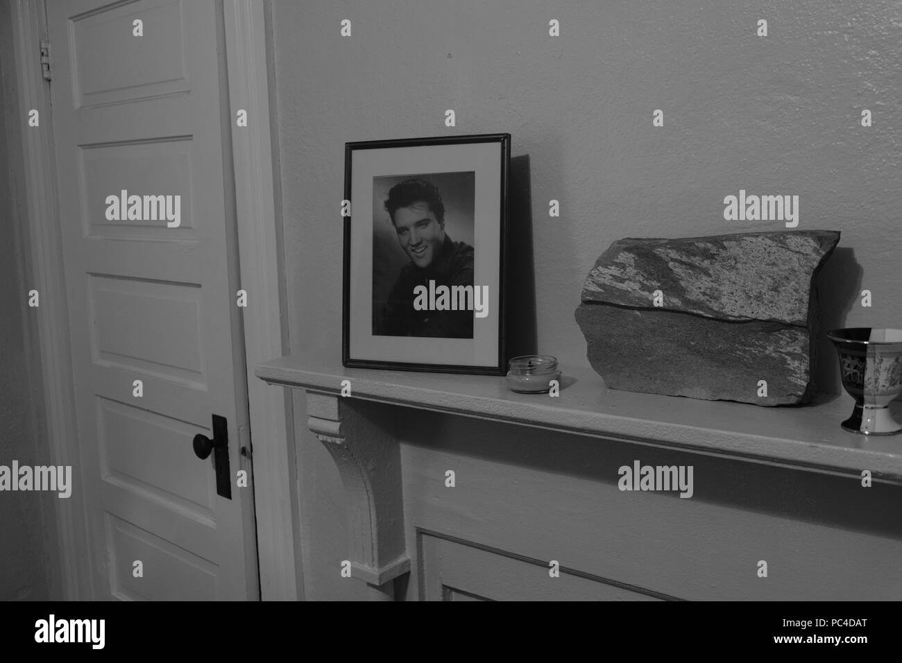 Gerahmten schwarzen und weißen Elvis Presley Bild auf einem Mantel in einer Wohnung mit einer weißen Tür daneben. Stockfoto