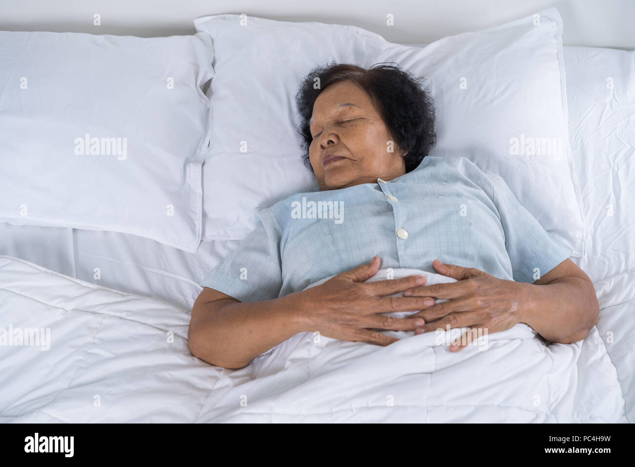 Alte Frau schlafen auf einem Bett im Schlafzimmer Stockfotografie - Alamy