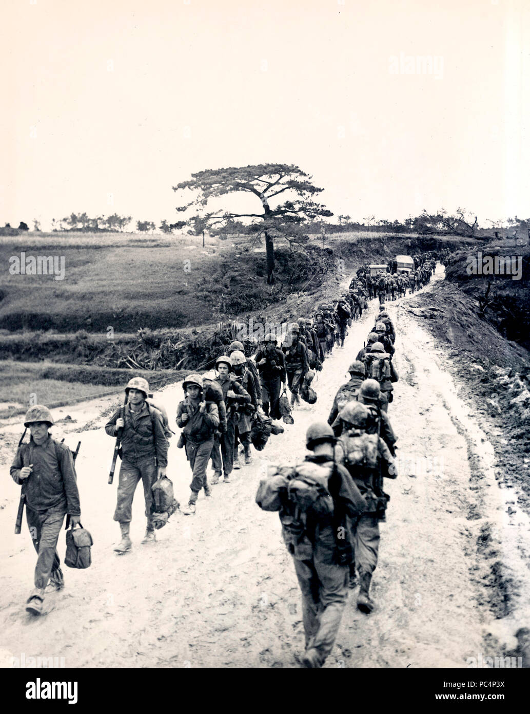 Eine Datei von Marines auf Okinawa bewegt sich in Richtung der Front, während eine andere Spalte Exerzitien für Erholung von den Kämpfen finden Stockfoto