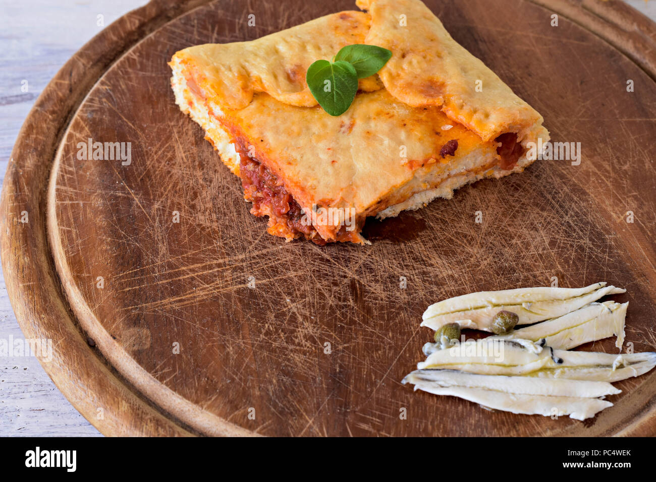 Stück leckeren Fisch pie, runde hausgemachten köstlichen Fisch pie auf Holzbrett whit gesalzener Fisch - Sardine/Mediterrane Küche Stockfoto