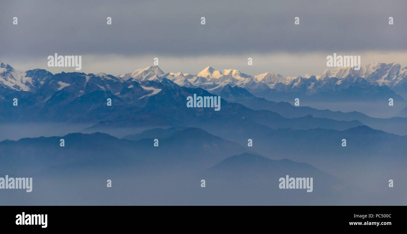 Die Himalaya Gebirge unter schweren Wolken, von einem lokalen Flug gesehen. Stockfoto