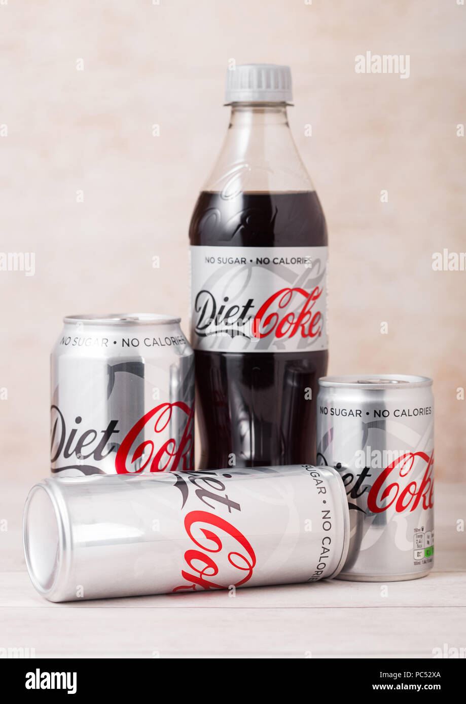 LONDON, UK - August 03, 2018: Plastikflasche und Aluminium Dosen Cola Coca Cola Erfrischungsgetränke auf Holz. Beliebteste Getränk in der Welt. Stockfoto