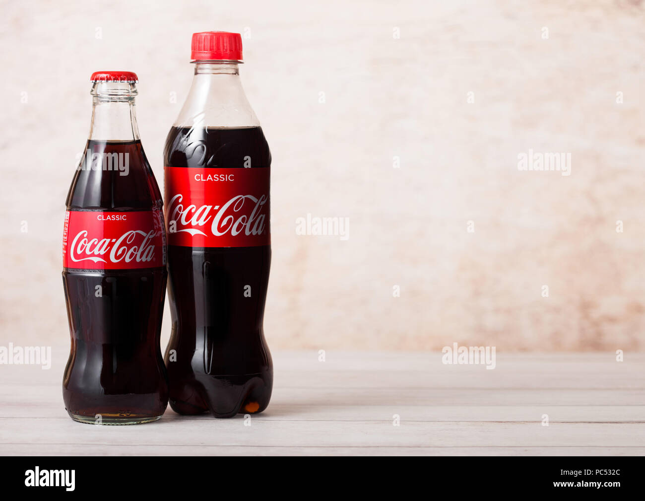 LONDON, UK - August 03, 2018: Kunststoff und Glas Flasche Original Coca Cola Erfrischungsgetränke auf Holz. Beliebteste Getränk in der Welt. Stockfoto