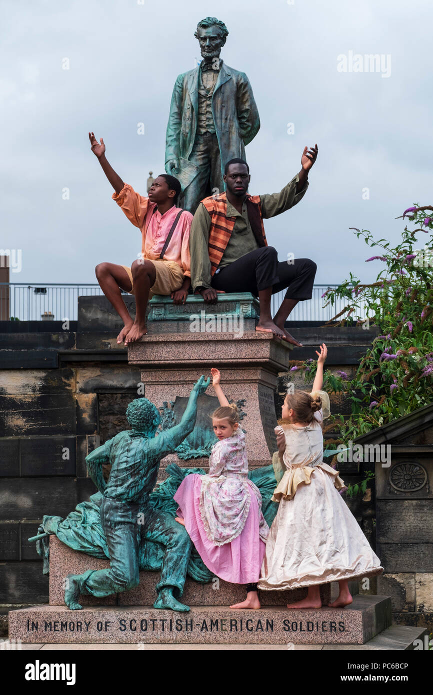 Edinburgh, Schottland, Großbritannien; 1. August, 2018. Die Besetzung von Henry, Braun: Eine musikalische Reise an der Statue von Präsident Lincoln in der Alten Calton Grabstätte, Edinburgh. New York Gospel Singers aus einem neuen Edinburgh Fringe Musical über eine amerikanische Sklaven in die Freiheit in einem 3 ftX 2 ft Lieferumfang Raffung im Amerikanischen Bürgerkrieg Memorial die Schotten, die sich gegen die Sklaverei in den Amerikanischen Bürgerkrieg kämpften zu ehren. Credit: Iain Masterton/Alamy leben Nachrichten Stockfoto