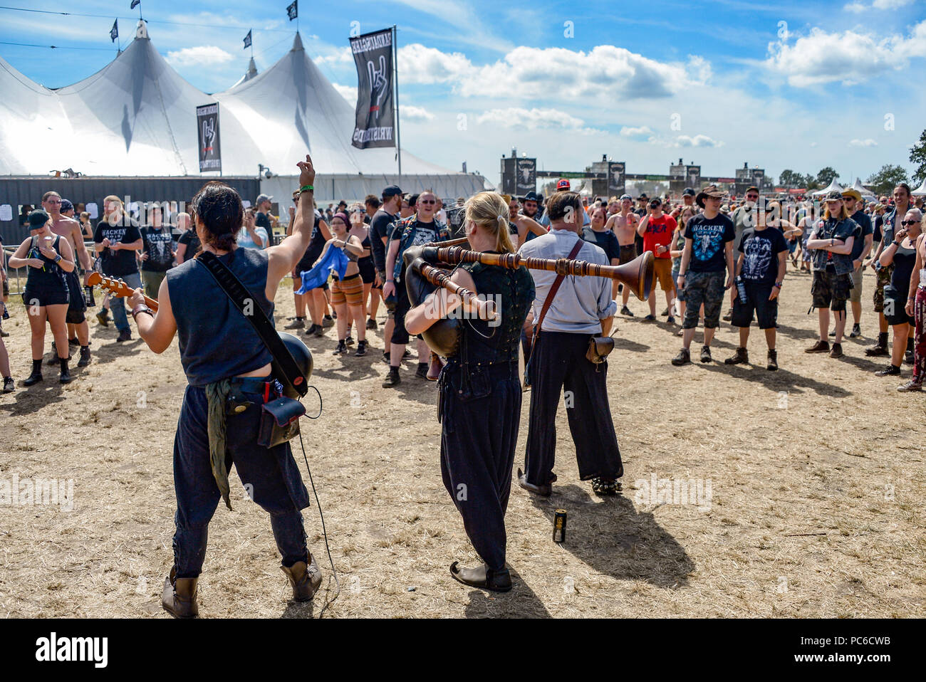 Wacken, Deutschland. 01 Aug, 2018. Festivalgoers hören zu einer Band spielt auf dem Campingplatz in der prallen Sonne. Die traditionellen Schlamm Schlacht hat bisher nicht stattfinden, und es ist eine Bedrohung der Hitze der Schlacht. Quelle: Axel Heimken/dpa/Alamy leben Nachrichten Stockfoto