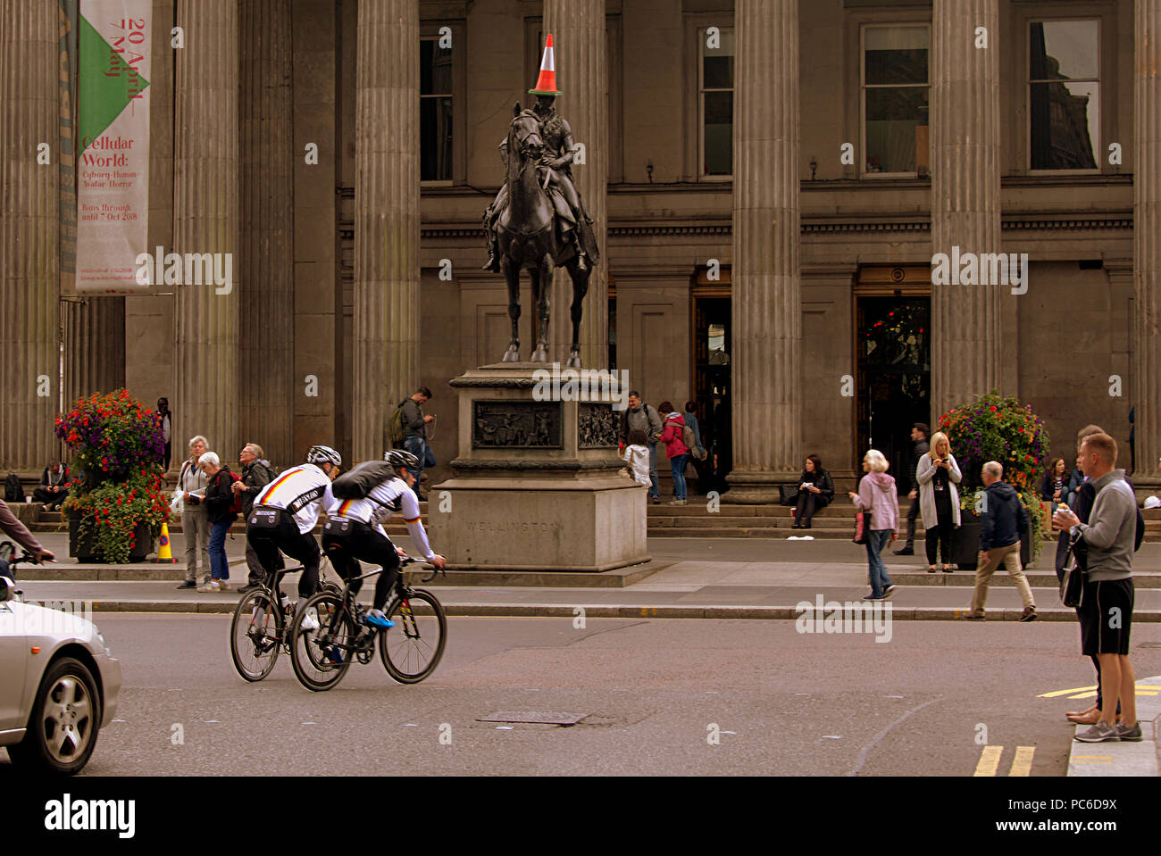 Glasgow, Schottland, Großbritannien 1. August. Die Europäischen Meisterschaften beginnen in der Stadt und Berlin gleichzeitig als Stadt Banner für den sportlichen Feier im Zentrum der Stadt. Als deutsche Mountainbike Konkurrenten Tour die Stadt vor der Herzog von Wellington statue iconic Kegelspitze Mann außerhalb der modernen Kunst Galerie der Stadt Goma Gerard Fähre / alamy Nachrichten Stockfoto