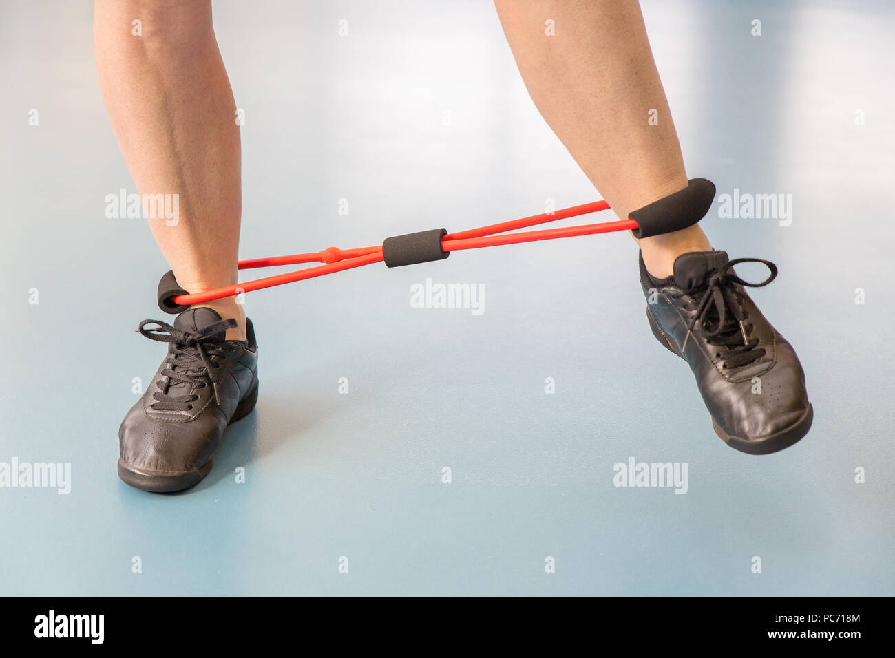 Zwei weibliche Beine mit elastischen tun Muskel Übungen im Fitnessstudio Klasse Stockfoto