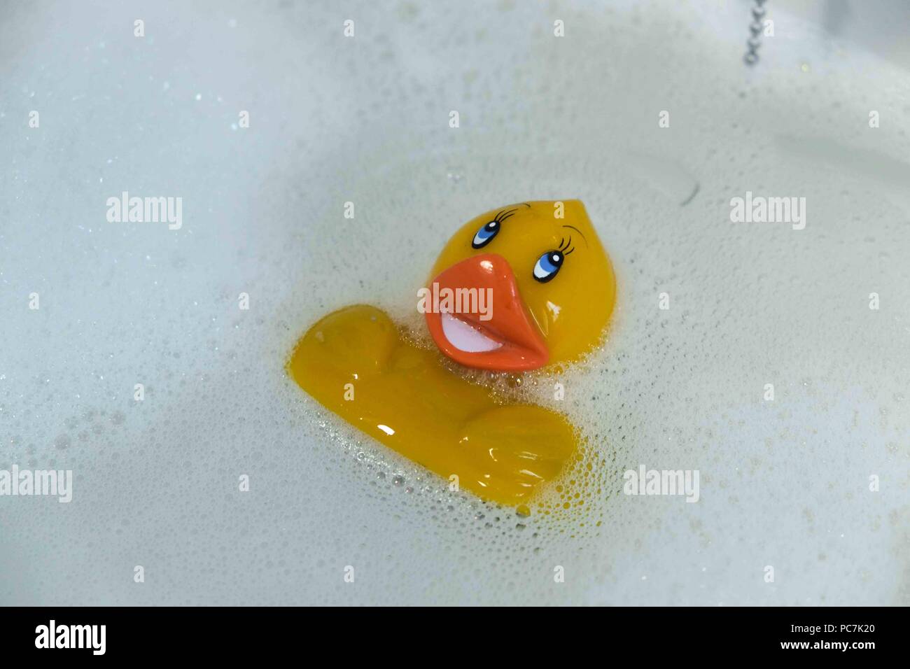 Gelbe Gummiente in ein Waschbecken mit Wasser Stockfoto