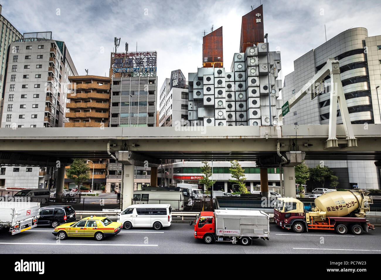 Nakagin Capsule Tower und konkrete Apartment Gebäude hinter der Hochbrücke Straße von Shuto Expressway in Shimbashi, Tokio, Japan. Die Nakagin Capsule Stockfoto