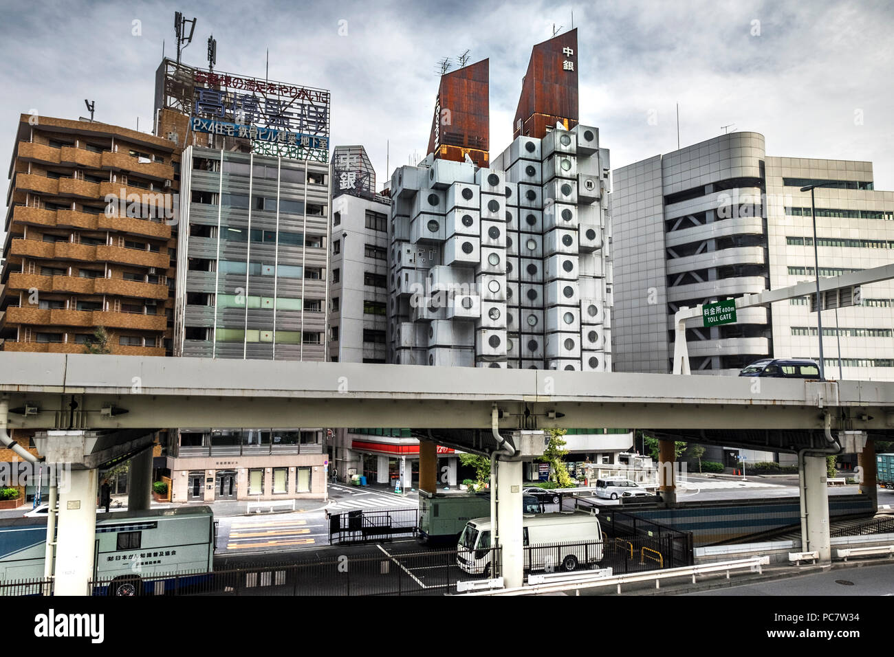 Nakagin Capsule Tower und konkrete Apartment Gebäude hinter der Hochbrücke Straße von Shuto Expressway in Shimbashi, Tokio, Japan. Die Nakagin Capsule Stockfoto