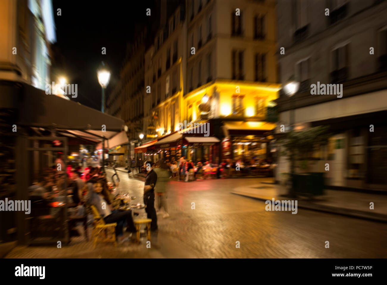 Verschwommene Bewegung Bild von Menschen in Cafes und Bistros in der Nacht in Paris. Stockfoto