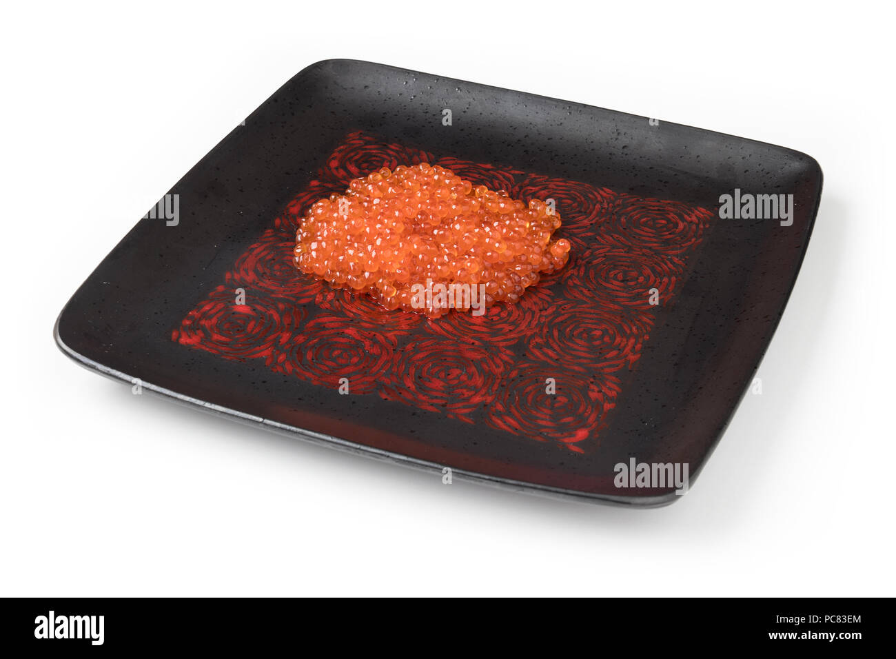 Roter Lachskaviar auf einem schwarzen, quadratischen Platte, isoliert auf weißem Stockfoto
