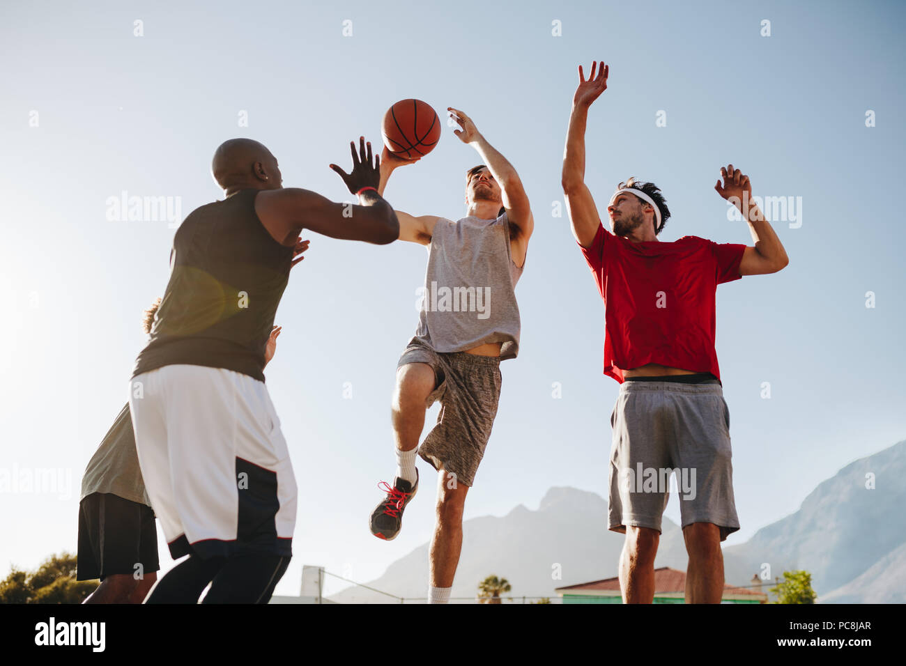 Männer spielen Basketball Spiel an einem sonnigen Tag. Männer üben Basketball Dribblings. Stockfoto