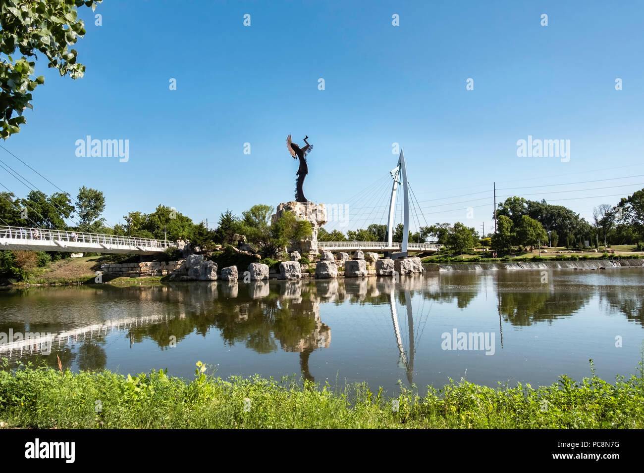 Hüter der Plains, eine stählerne Skulptur von Blackbear Bosin und eine Fußgänger-Hängebrücke. Wichita, Kansas, USA. Stockfoto